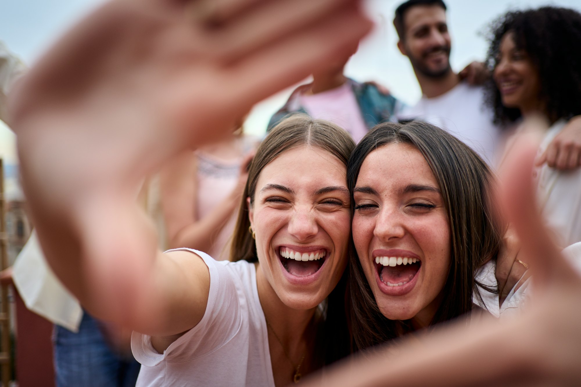 Capturing moments. Portrait of two Caucasian beautiful girls making photo frame with hands at party.